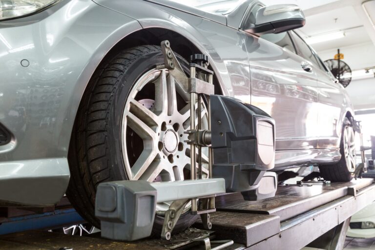 Closeup of tire clamped with aligner undergoing auto wheel align