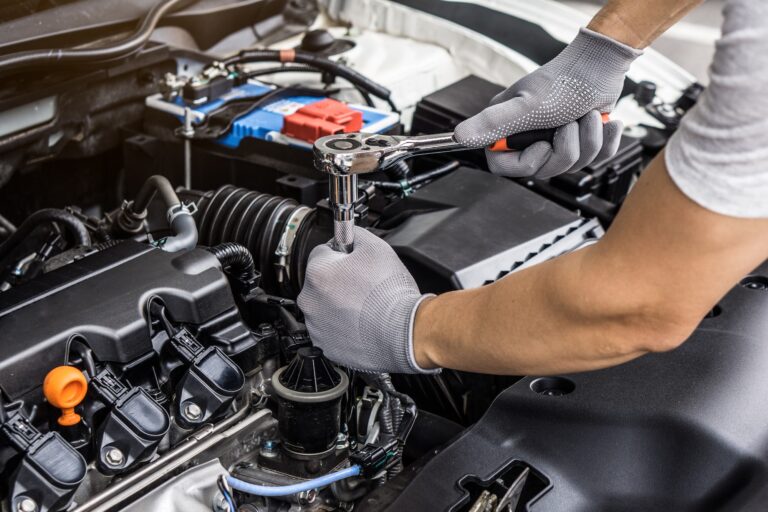 Mechanic man working on the engine of the car in the garage.Car service and maintenance.