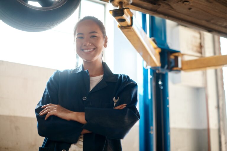 Shot of a female mechanic posing with her arms crossed in an auto repair shop