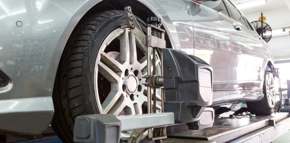 Closeup of tire clamped with aligner undergoing auto wheel align