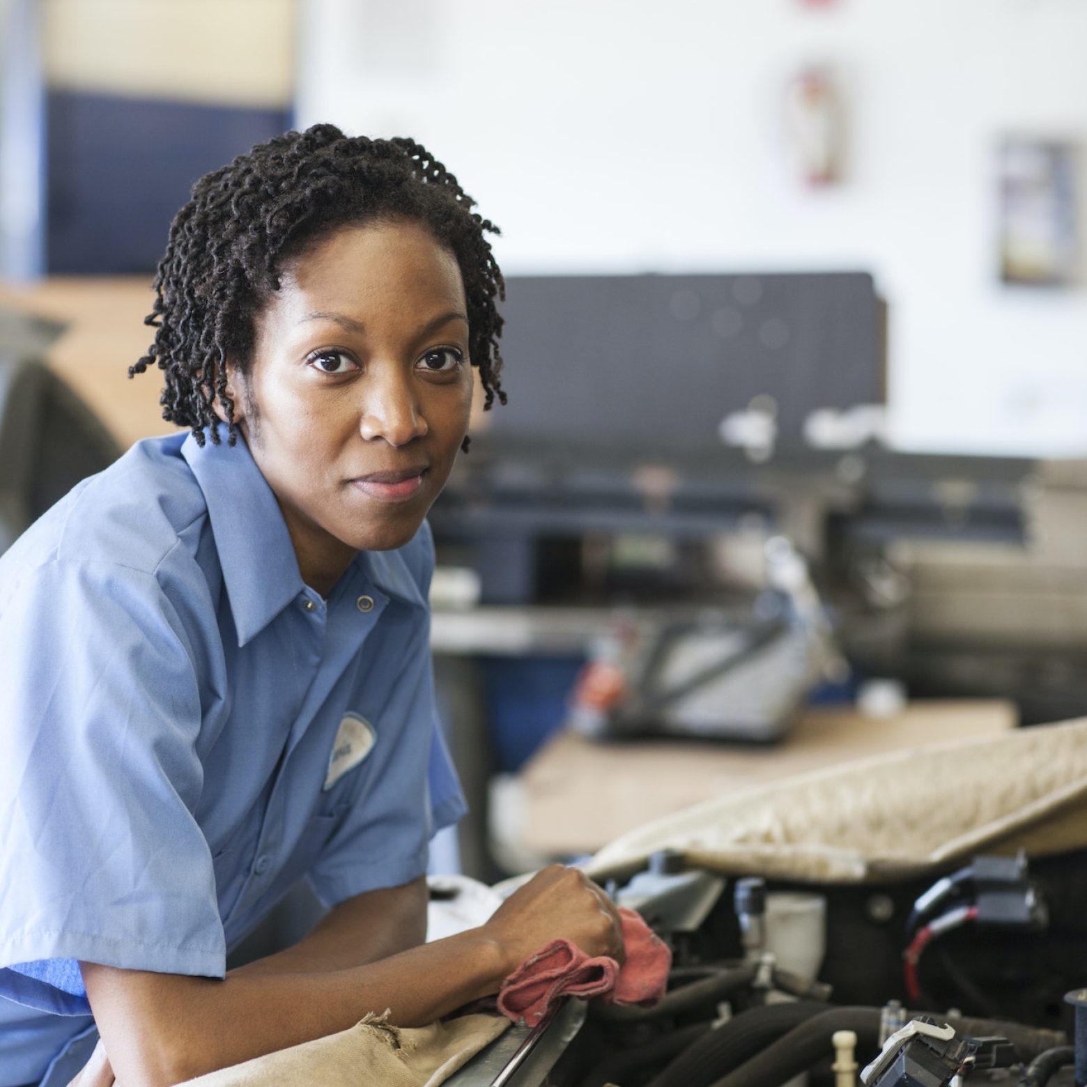 Portrait of smiling black female mechanic in auto repair shop