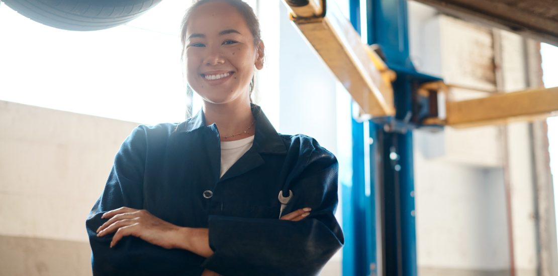 Shot of a female mechanic posing with her arms crossed in an auto repair shop
