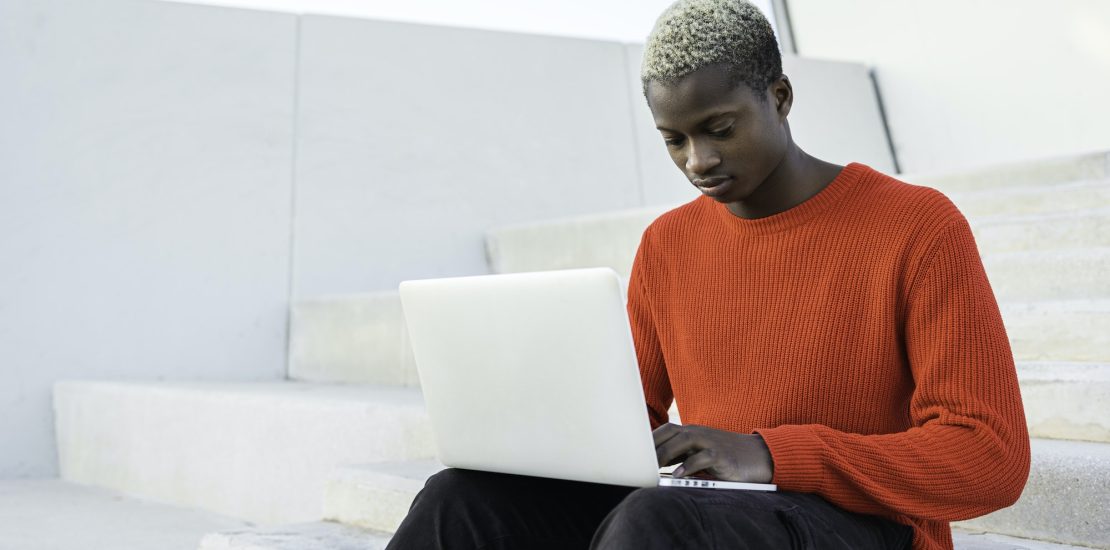 Young African american man with laptop computer.